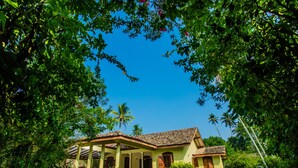Una casa con tetto in tegole, un portico coperto e una piscina.