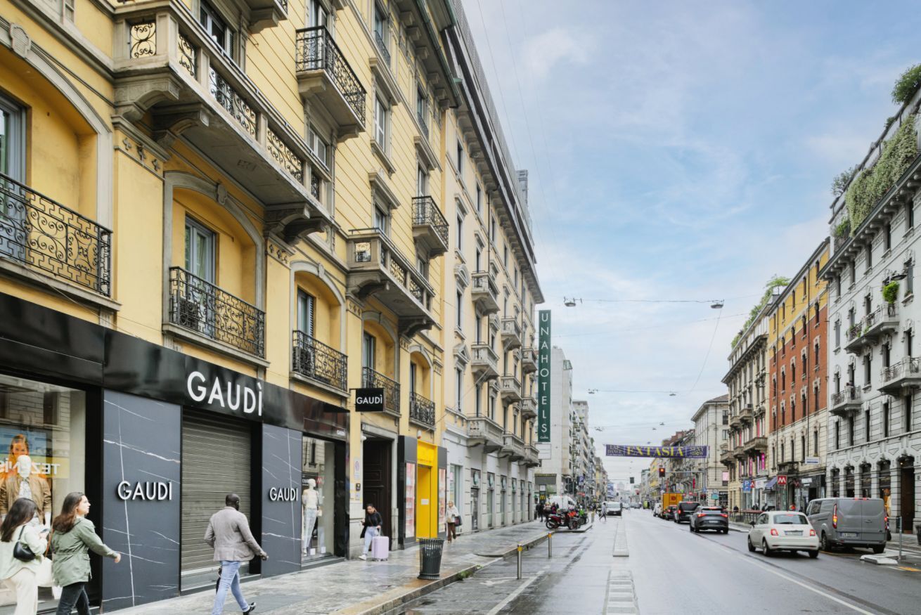 Une vue de rue avec un bâtiment sur lequel on peut voir l’enseigne « GAUDI », indiquant qu’il s’agit d’un hôtel ou d’un établissement commercial.
