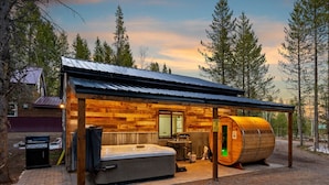 Una cabaña con sauna, jacuzzi y fachada de madera.