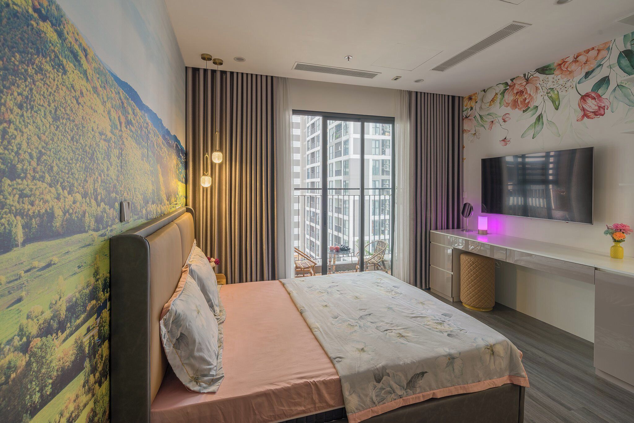 A hotel room with a bed, a desk, a TV, and a large window with a view of buildings.