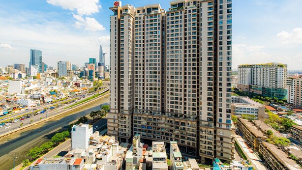 A high-rise building with multiple floors, surrounded by a cityscape. - River Gate Quan 4 Luxury Apartment (Ho Chi Minh City)