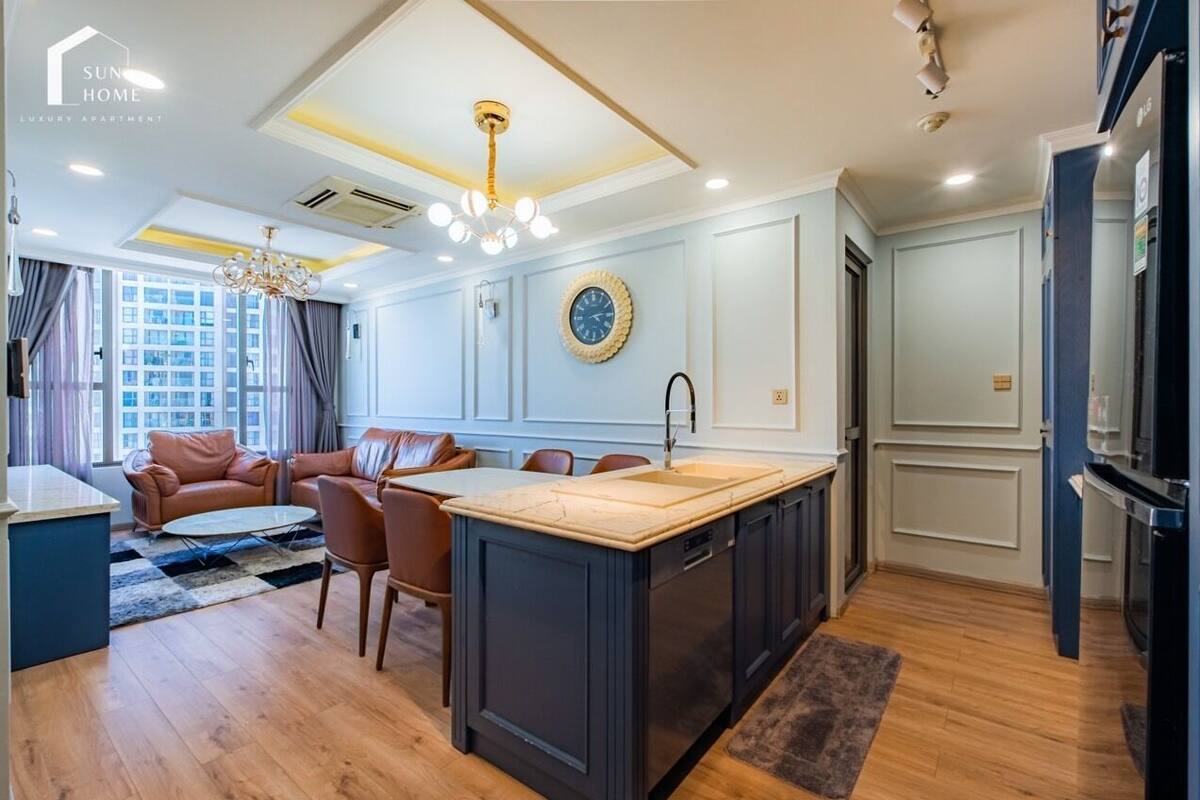Uma cozinha moderna com uma ilha central, eletrodomésticos embutidos e uma área de jantar com cadeiras de couro.