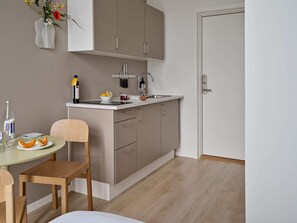 A modern kitchen with a dining area, featuring a sink, cabinets, and a table with chairs.