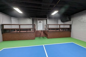 A room with bunk beds, a staircase, and a tennis court.