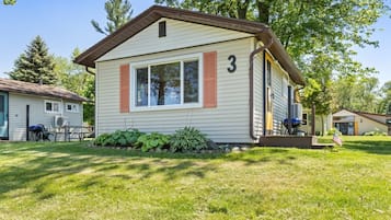 A single-story mobile home with a number '3' on the side, a small porch, and a well-maintained lawn.
