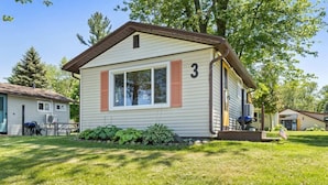 A single-story mobile home with a number '3' on the side, a small porch, and a well-maintained lawn.