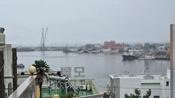 A harbor with boats, a crane, and buildings in the background.