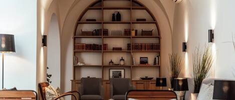A cozy living room with a large arched bookshelf, comfortable seating, and modern decor.