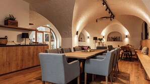 Un grand espace dédié à la salle à manger, avec une longue table en bois, plusieurs chaises et un banc.