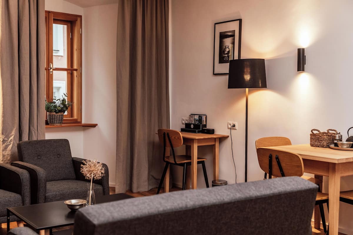 Una sala acogedora con sofá, mesa de comedor y lámpara.