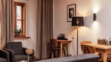 A cozy living room with a sofa, a dining table, and a lamp.