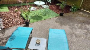 A patio with two turquoise sun loungers, a small table, and a chair. - La Pléïade Dorée - Hyper Centre, Avec Cours Privative. Animaux Acceptés ! (Amiens)