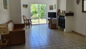 Olohuone, jossa on takka, televisio ja nojatuoli.