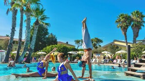 A swimming pool area with people relaxing and performing acrobatics. - Residence with swimming-pool in Arborea  (Arborea)