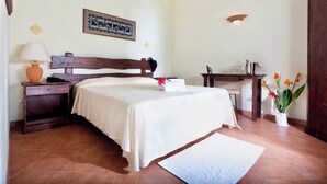 A neatly arranged bedroom with a bed, bedside table, lamp, and a small desk with a chair. - Residence with swimming-pool in Arborea  (Arborea)