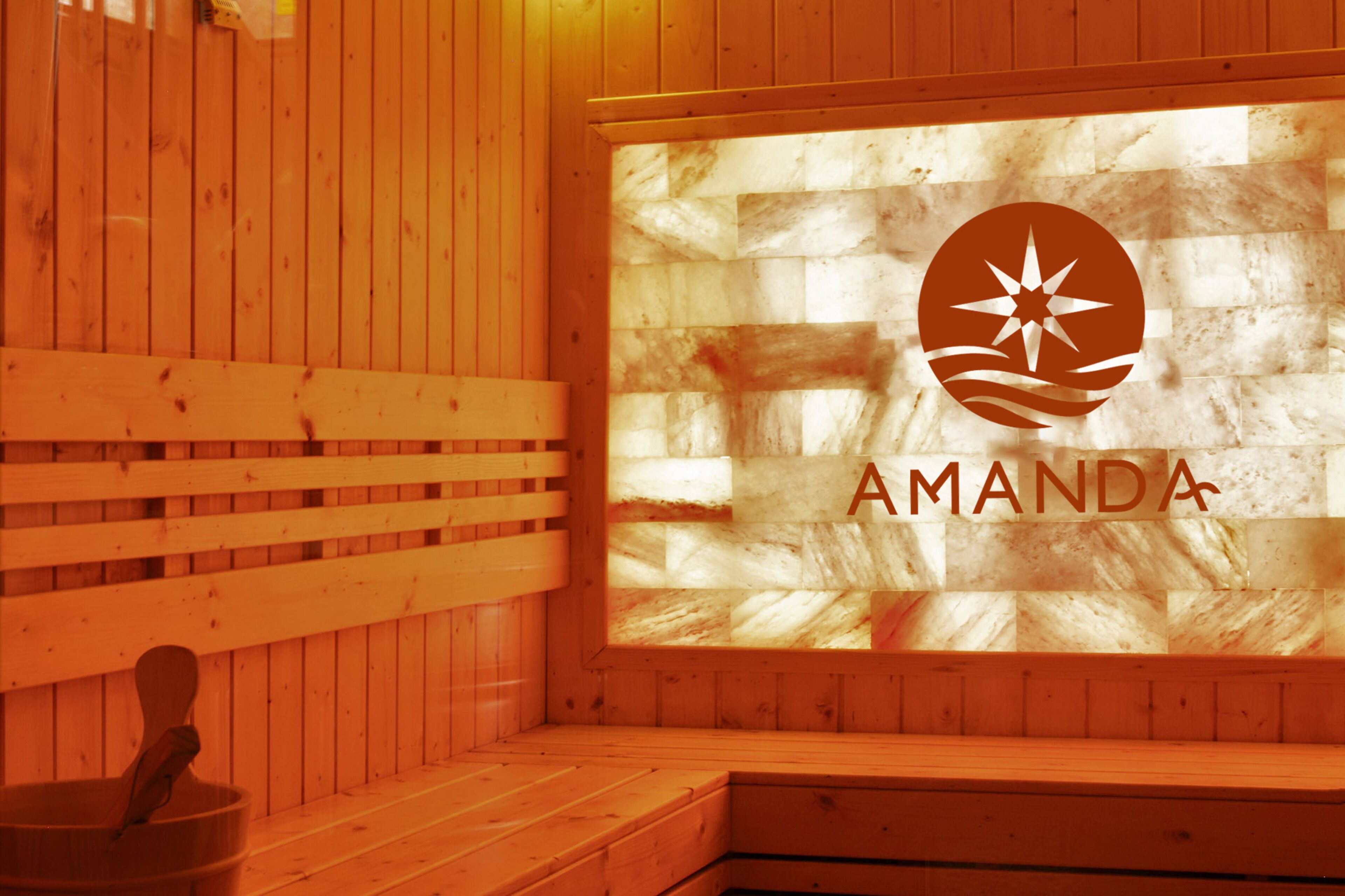 A wooden sauna with a logo and the name 'AMANDA' on a glass wall.