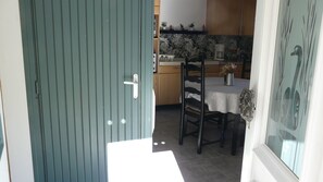 Eine Küche mit Esstisch, Stühlen und einem Schrank.