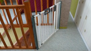 Una puerta de madera que da a un cuarto con piso de baldosas y pared verde.