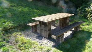Una mesa de picnic de madera con bancos en un césped.