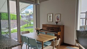 Ein Essbereich mit Klavier, Stühlen und Tisch.