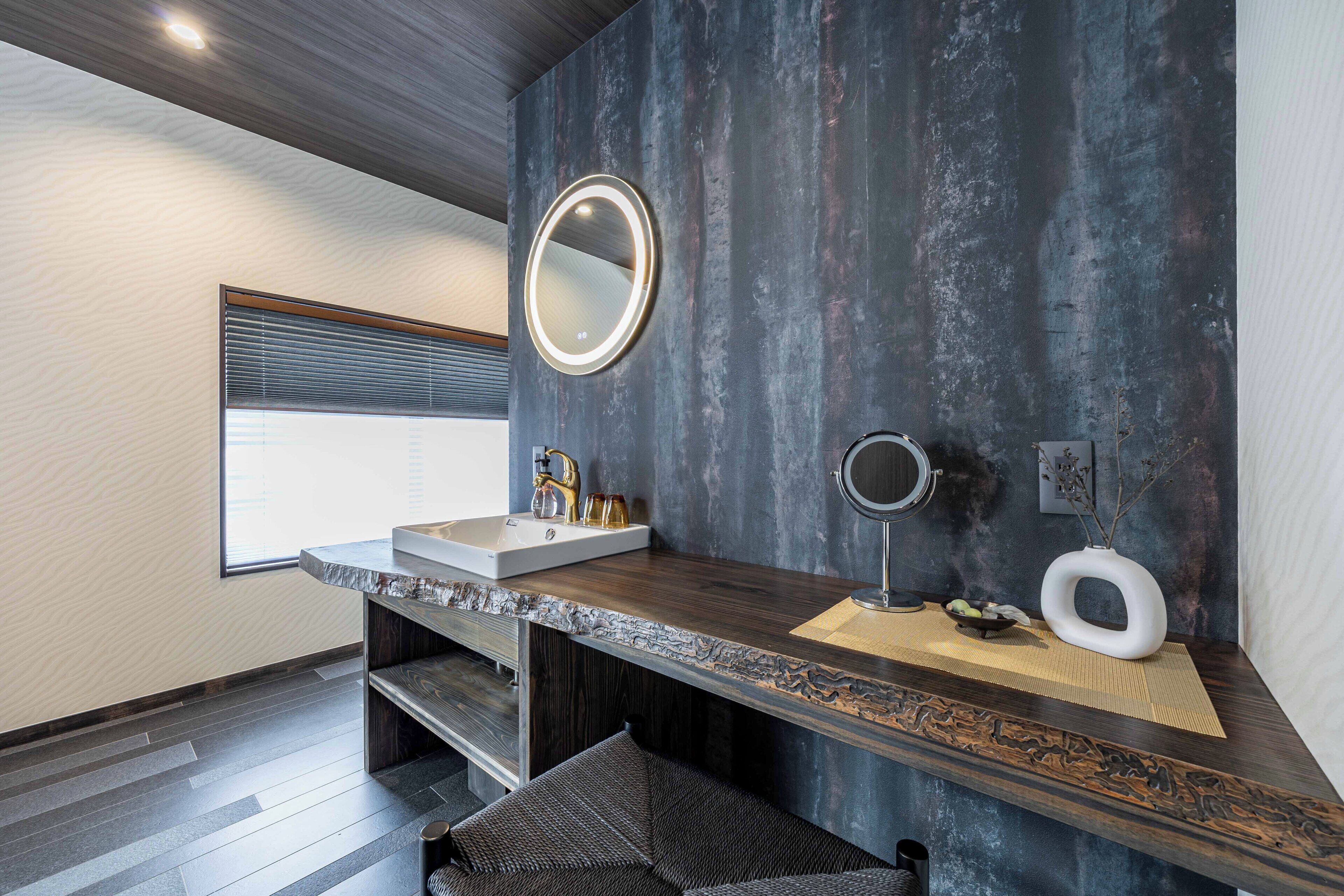 A modern bathroom with a large mirror, a sink, and a toilet.