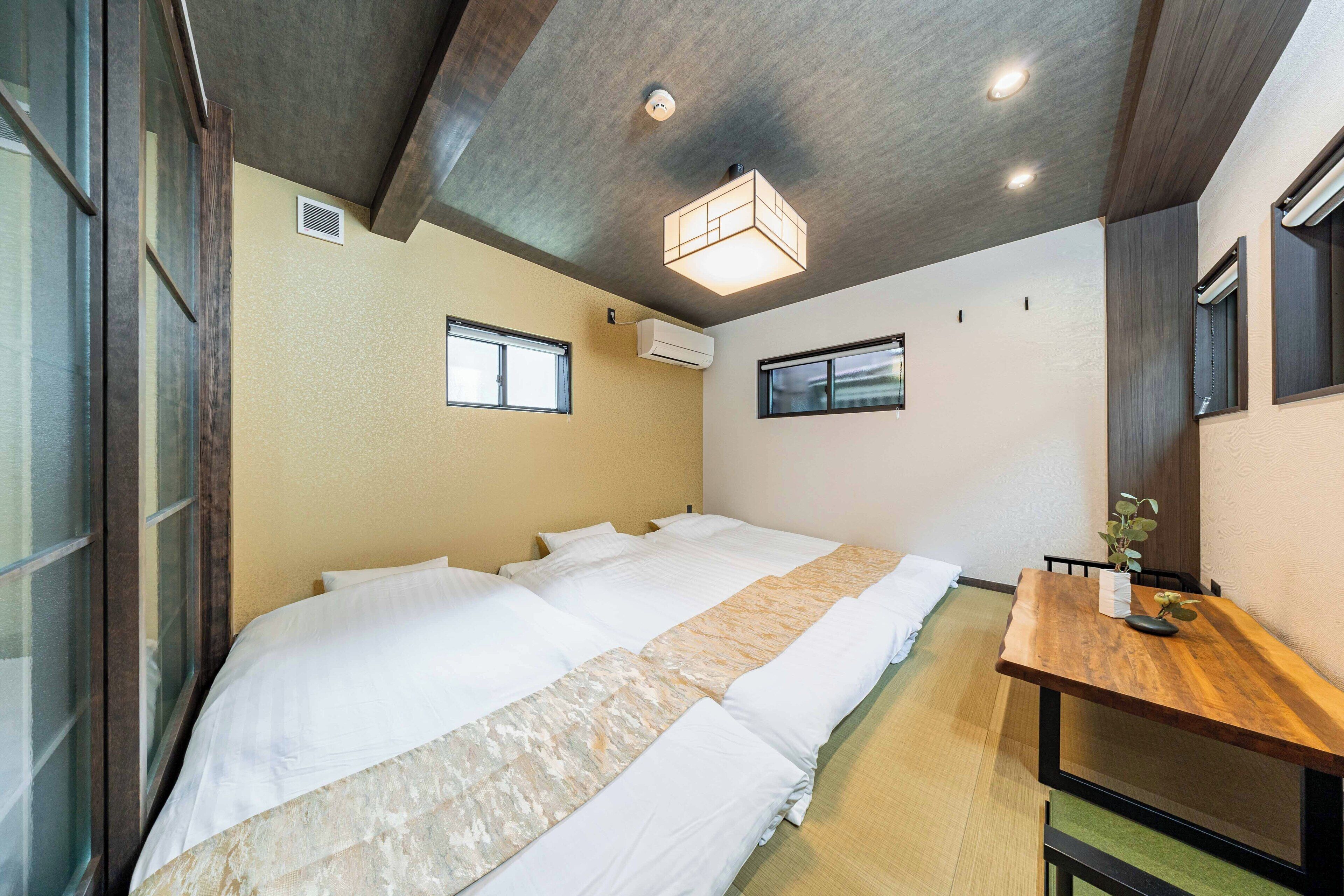A hotel room with a large bed, a wooden desk, and a ceiling light fixture.
