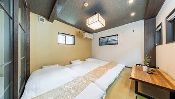 A hotel room with a large bed, a wooden desk, and a ceiling light fixture.
