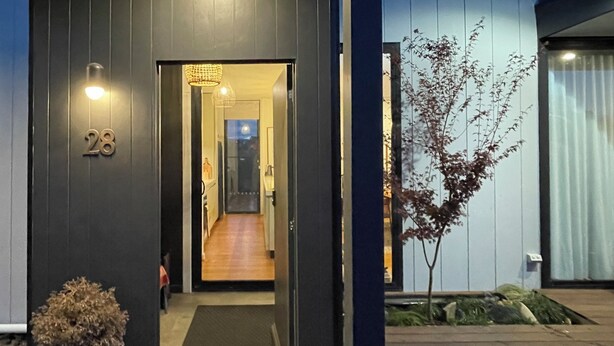 A modern building with a dark facade, a visible entrance, and a potted plant in the foreground. - Cosy “Mod” in Clunes  (Clunes)