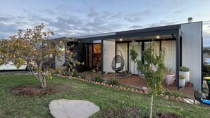 A modern house with a patio, a hanging chair, and potted plants. - Cosy “Mod” in Clunes  (Clunes)