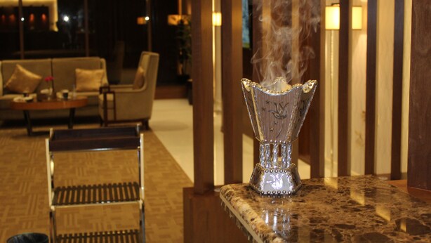 A marble countertop with a decorative glass vase emitting steam. - Pestana Hotel & Suites 3 (Riyadh)