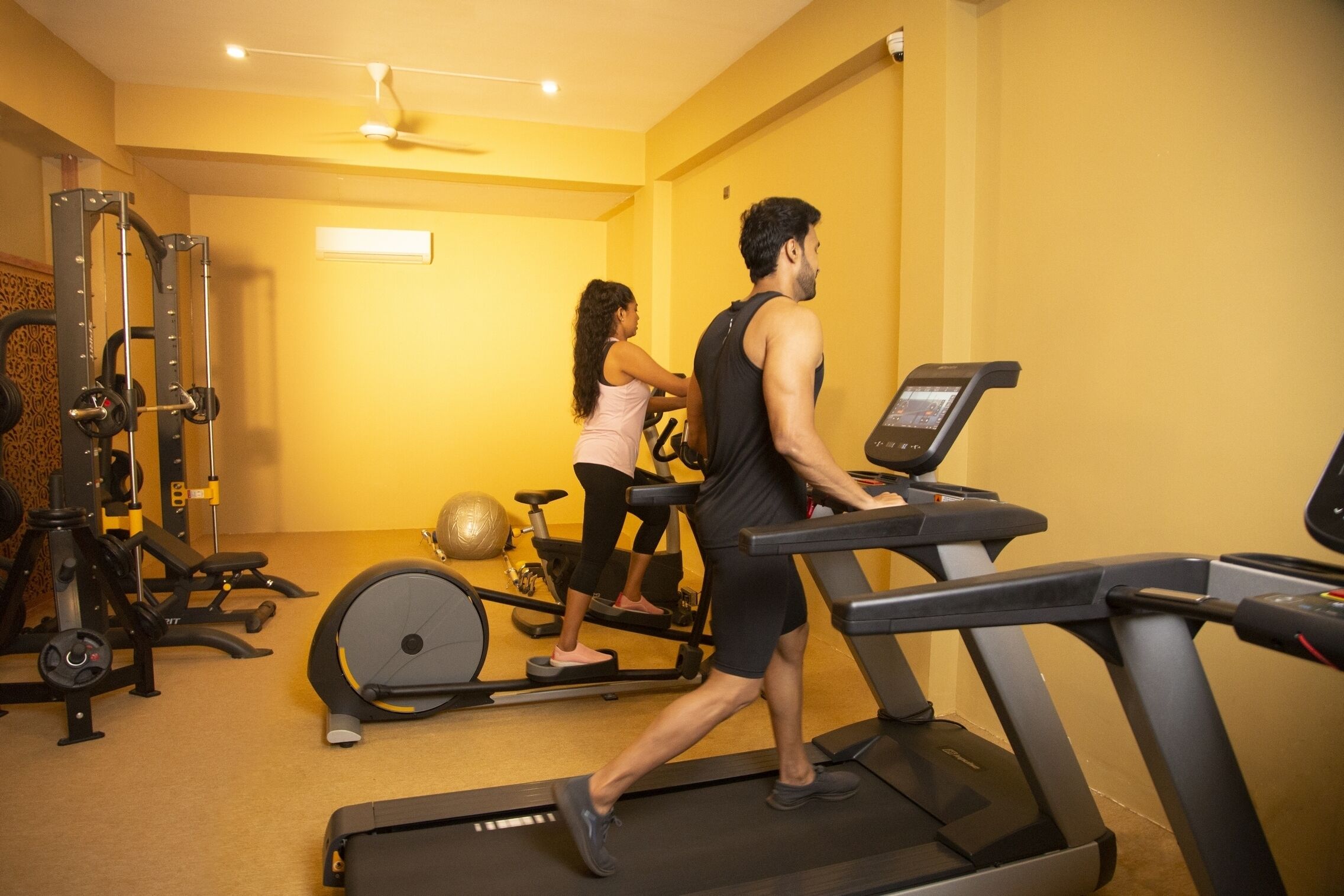 A gym with treadmills, an elliptical, and weight machines.