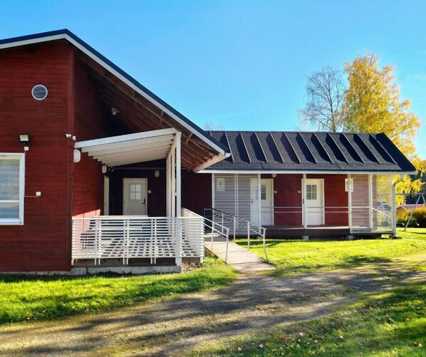 A red building with a covered porch and a separate section with a sloped roof. - Taiga Resort (Oulu)