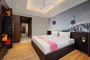 A modern hotel room with a large bed, wooden flooring, a ceiling fan, a ski lift mural, and built-in shelving. - Ginger Srinagar Barzulla (Srinagar)