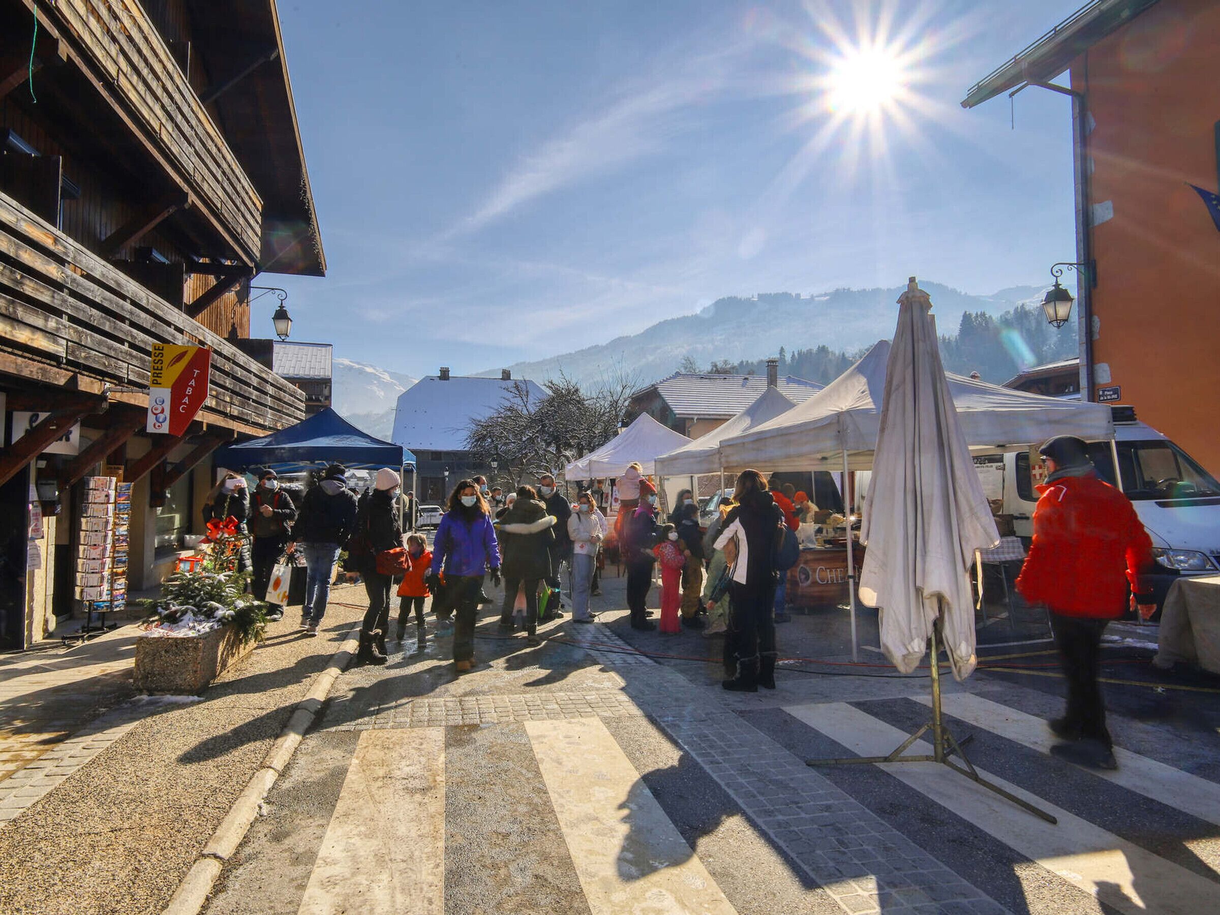 A street market with tents and people walking.