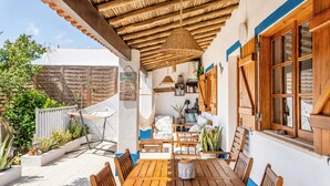 A wooden table with chairs, a hanging lamp, and a white wall with a blue trim. - Traditional Algarve home with private pool, air con & solar, near Praia Marinha (Lagoa)