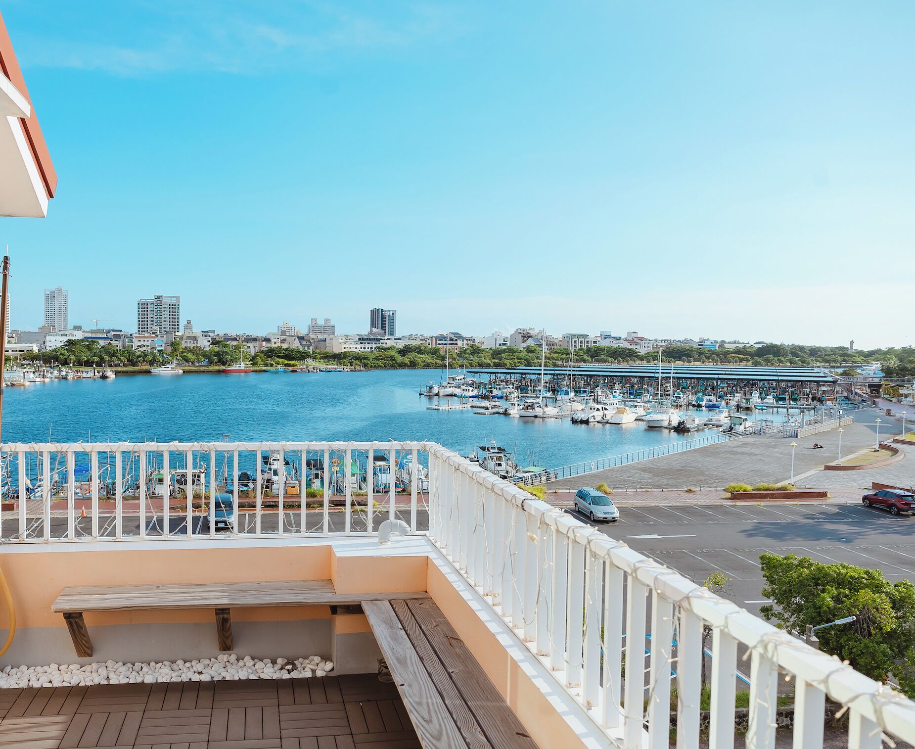 A balcony with a view of a marina and city skyline.