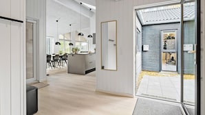 A modern kitchen with a central island, pendant lighting, and a large mirror.