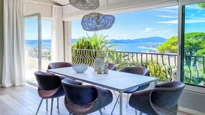 A dining area with a table and chairs, a decorative bowl, and a view of the sea and greenery. - Exklusives Ferienhaus mit Traumhaftem Meerblick in Sainte Maxime (Sainte-Maxime)