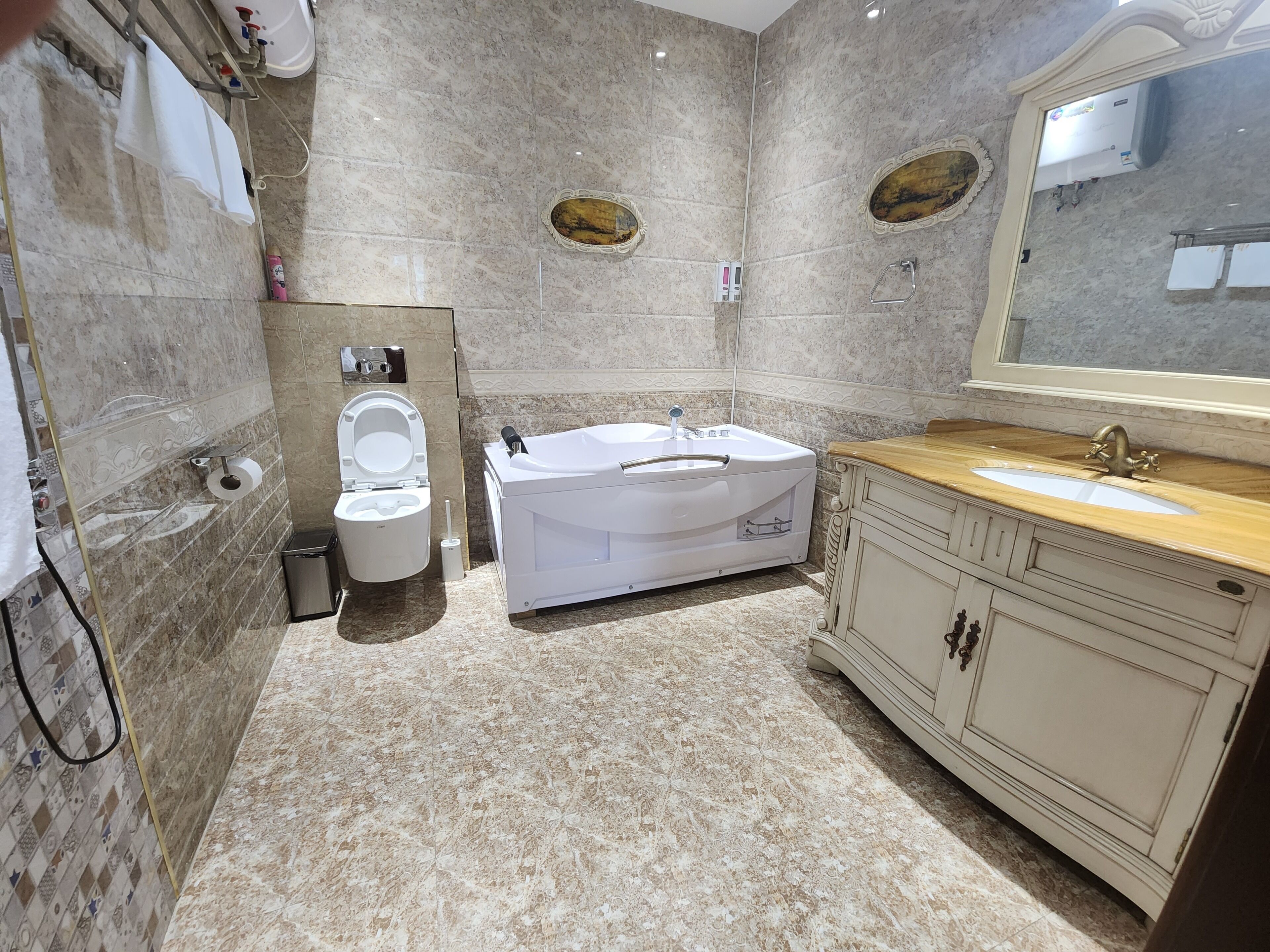 Ein Badezimmer mit Toilette, einer Badewanne, einem Waschbecken und einem Spiegel.
