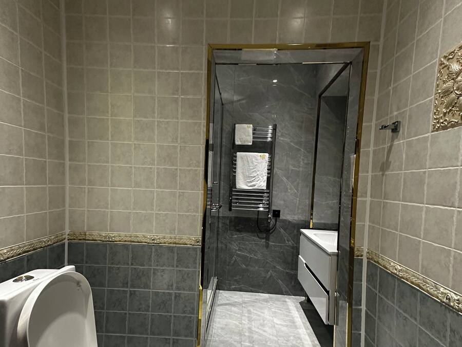 Une salle de bain moderne équipée de toilettes, d’un lavabo et d’un espace douche.