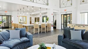 A spacious lobby with a high ceiling, modern furniture, and a foosball table. - TWO CozySuites at Kierland Commons  (Scottsdale)