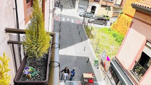 An outdoor café area with tables and chairs, surrounded by buildings with balconies and windows. - Centro y Confort by Wehomes (Santander)