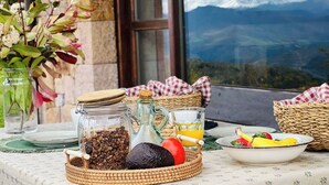 Una mesa dispuesta con artículos para el desayuno, incluyendo un tarro de cristal, una jarrón, un bol de fruta y una cesta.