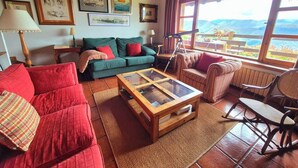 Una sala de estar acogedora con un sofá, un sillón y una mesita de centro.
