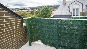 Zona residencial amb mur de maó, un bord i una casa amb teulada inclinada.