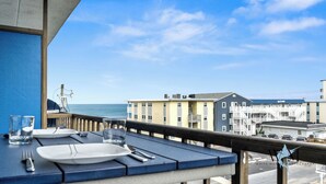 A table set for dining with a view of the ocean and buildings in the background. - 1 Bedroom Ocean View Condo with Community Pool (Ocean City)