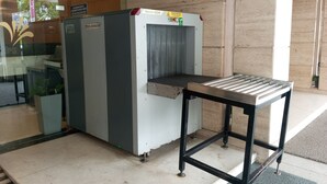 Puesto de seguridad con detector de metales y cinta transportadora.