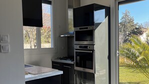A modern kitchen with built-in appliances, a large window, and a view of the outdoors. - Villa with pool and air conditioning (Carpentras)