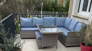 A patio area with a wicker sofa set, a glass-top coffee table, and two potted plants. - Villa with pool and air conditioning (Carpentras)