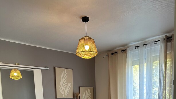 A bedroom with a bed, a bedside table, a hanging light fixture, and a window with curtains. - Villa with pool and air conditioning (Carpentras)